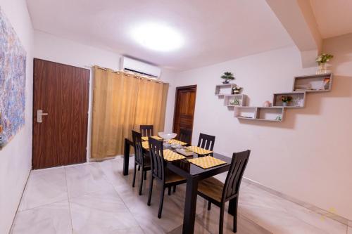 a dining room with a black table and chairs at HomeAwayFromHome Villa in Lapaz