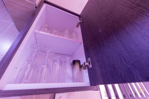a cabinet filled with glass bottles on a shelf at HomeAwayFromHome Villa in Lapaz