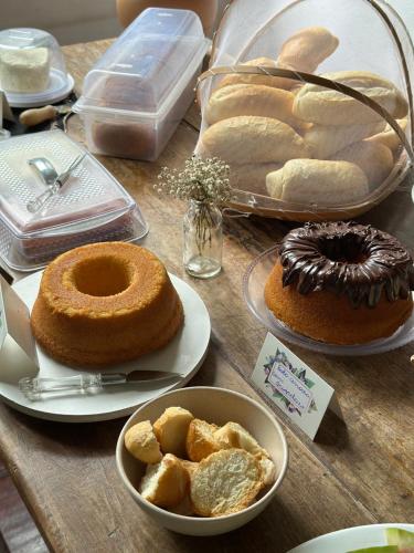 a table with different types of bread and pastries at Hostel 040 in Itaipava
