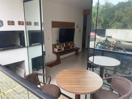 Una habitación con una mesa y sillas y un balcón. en Apto super amplo e confortável, en Piçarras