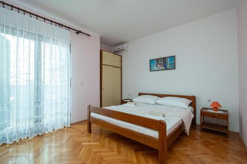 ein Schlafzimmer mit einem Bett und einem großen Fenster in der Unterkunft Apartments and rooms with parking space Zubovici, Pag - 16063 in Zubovići