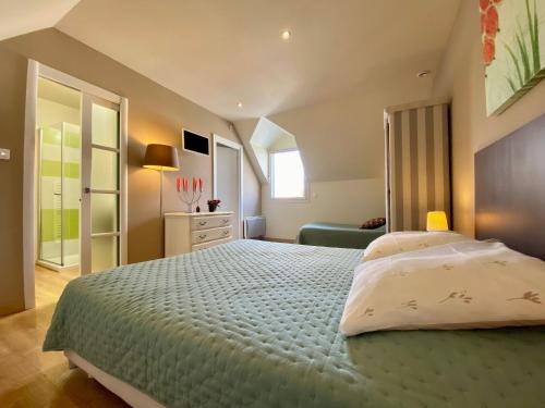 a bedroom with a large bed and a couch at Gîte calme près de plages, au cœur de Batz-sur-Mer, terrasse sud, wifi, et équipements bébé - FR-1-306-840 in Batz-sur-Mer