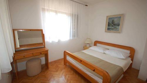 una camera con letto e comò con specchio di Apartments with a parking space Njivice, Krk - 21869 a Njivice
