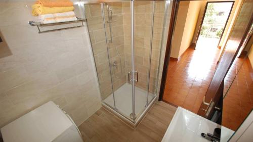 La salle de bains est pourvue d'une douche avec une porte en verre. dans l'établissement Apartments with a parking space Njivice, Krk - 21869, à Njivice