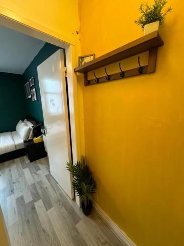 a hallway with a yellow wall with plants on it at Unique Studio Flat in City 1110 in London