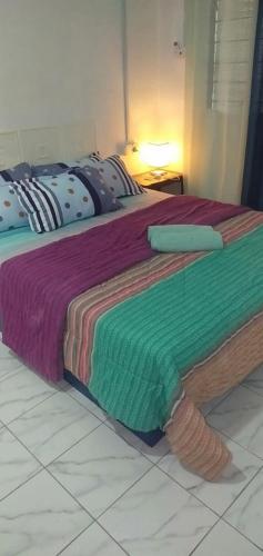 a bedroom with two beds with colorful blankets at Sunset House Labuan Homestay 
