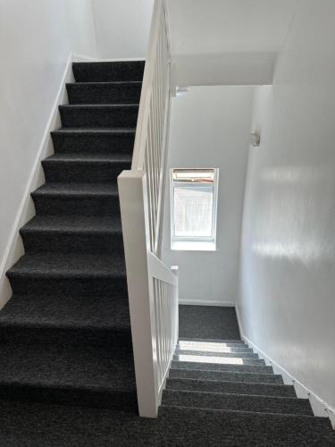 a staircase with white walls and black carpet at Unique Studio Flat in City 1110 in London