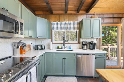 una cocina con armarios verdes y fregadero en 3 Br Vt Retreat W New Kitchen, Gamemedia Rooms, en Wilmington