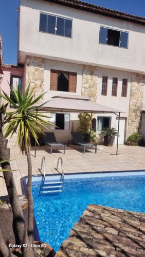 a villa with a swimming pool in front of a building at Casa com piscina e lazer em SBC SP in São Bernardo do Campo