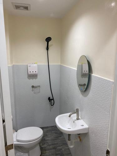 uma casa de banho com um WC, um lavatório e um espelho. em 4VJ's Apartelle em Pooc