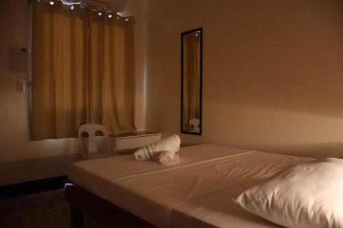 um quarto com uma cama com um espelho e uma janela em 4VJ's Apartelle em Pooc