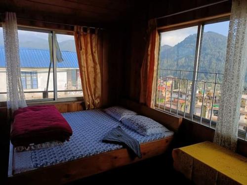 Cama en habitación con ventana y vistas en Valley view homestay, en Lava