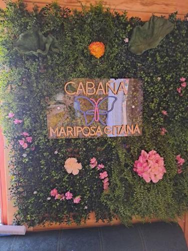 a book with flowers and a butterfly on it at Cabaña Gitana - Magical and WINDY nature getaway! in Jardín