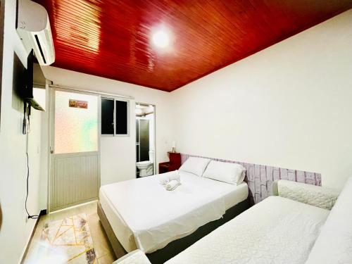 a room with two beds and a tv at De Greiff House in San José del Guaviare