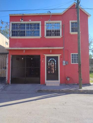 マタモロスにあるHabitación 2, 1 Cama Matrimonialの門と赤い扉のある赤い建物