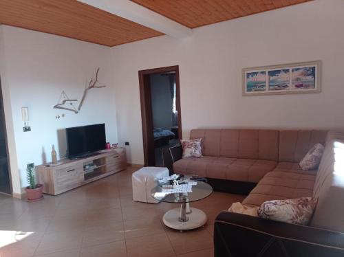 a living room with a couch and a tv at Private House Durres in Durrës