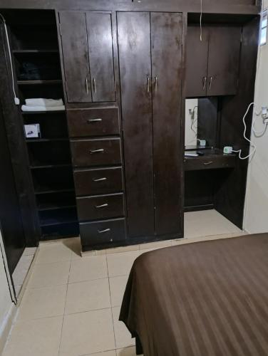 1 dormitorio con armarios de madera oscura y escritorio en Habitación 2, 1 Cama Matrimonial en Matamoros