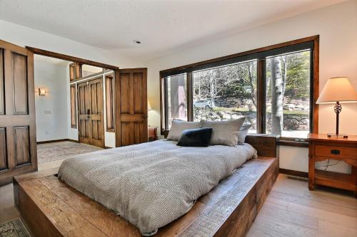 een slaapkamer met een groot bed en een groot raam bij Centrally Located, Close to Ski, Main Street, Free Resort Shuttle with Hot Tub in Park City