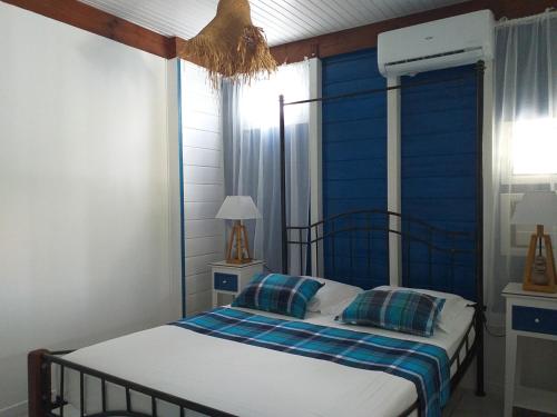 a bedroom with a bed with a blue headboard at Ti Bihan in Sainte-Anne