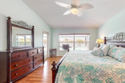 1 dormitorio con 1 cama con tocador y espejo en Beachcomber Getaway, en Fort Myers