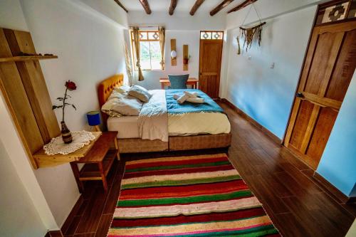 um quarto com uma cama e um tapete colorido em Blue Lotus Retreat Center em Písac