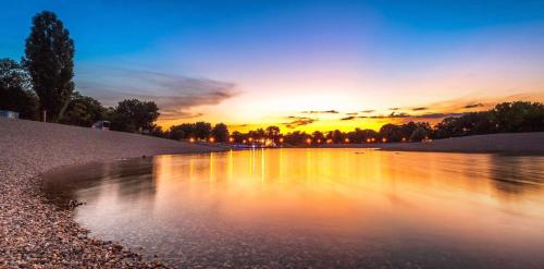 a body of water with the sunset in the background at Apartman Aurora Self Check in in Zagreb