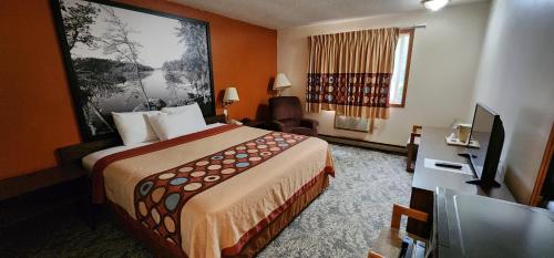 een hotelkamer met een groot bed en een televisie bij Stay Express Collection - Hotel Iron Mountain Inn & Suites in Iron Mountain