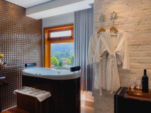uma casa de banho com uma banheira e uma janela em Hotel Harmonia Monte Verde em Monte Verde