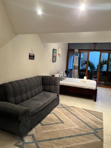 uma sala de estar com um sofá e uma cama em Fisherhut Beachfront Studios em Diani Beach