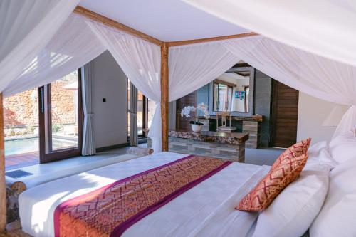a bedroom with a large bed with a canopy at 2 Seasons Villa Sun - Luxury with private pool in Ubud