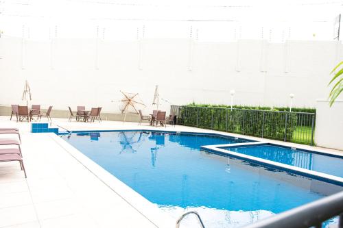 a swimming pool with blue water in a building at Apartamento Aconchegante próximo à Arena Castelão in Fortaleza