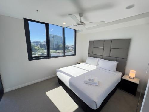 a bedroom with a white bed with a tray on it at Utopia Apartments by Serain Residences in Brisbane
