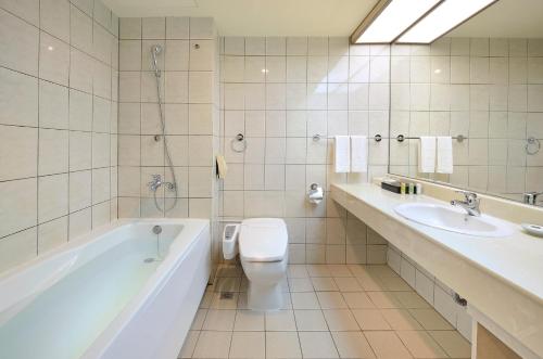 a bathroom with a tub and a toilet and a sink at Le Midi Hotel Jungli in Zhongli