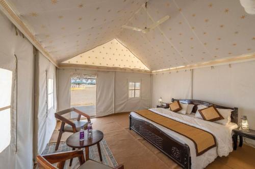 um quarto com uma cama e uma mesa num quarto em Royal Rangers Desert Safari Camp em Jaisalmer