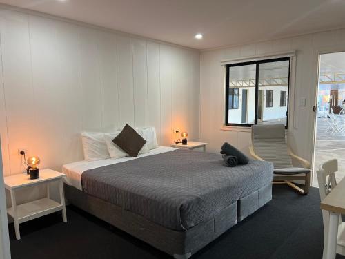 Abajaz Motel-All Rooms Updated-May 2024 في لونغريتش: غرفة نوم بسرير وكرسي ونافذة