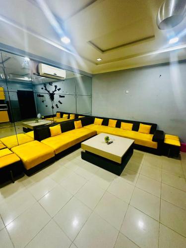 uma sala de espera com sofás amarelos e uma mesa em Appartment at bahria town em Rawalpindi