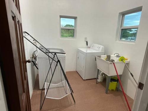 a bathroom with a washing machine and a sink at Tropical Villa at Lakeside View in Salisbury
