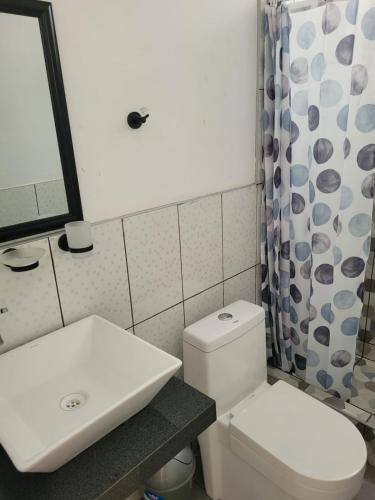 La salle de bains est pourvue de toilettes blanches et d'un lavabo. dans l'établissement Miel de luna, à Cerro Azul
