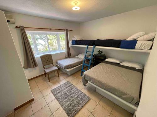 a bedroom with two bunk beds and a chair at Villa Grecia-Villas del Pacifico in San José de Guatemala