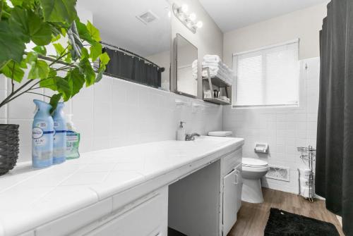 Baño blanco con lavabo y aseo en Suburban Bliss Getaway Wi-Fi Parking Long Stay en Center Point