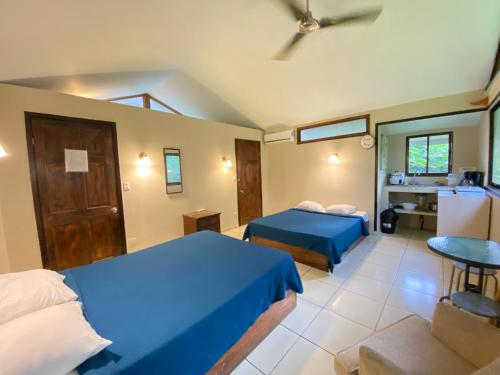 a hotel room with two beds and a bathroom at Finca Cristal con Piscina Room Blanca con AC in Punta Uva