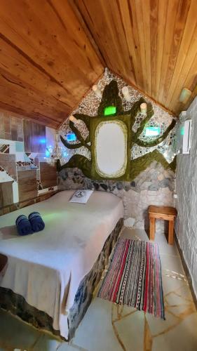 a bedroom with a large bed in a stone room at NOMADAS chales, mini casinhas, bangalôs e area de camping in Bonito