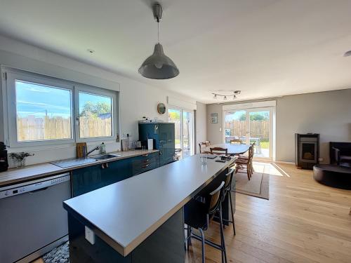 une cuisine avec un grand îlot au milieu dans l'établissement Villa moderne au calme, terrasse, jardin clos, à 500m de la plage de Kairon, proche commerces et loisirs - FR-1-361-372, à Saint-Pair-sur-Mer