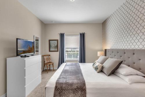 - une chambre avec un grand lit et une télévision dans l'établissement 4 Bedrooms 3 Bathrooms Lucaya Village 15-101, à Orlando