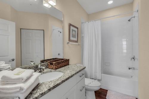 La salle de bains est pourvue d'un lavabo, de toilettes et d'une douche. dans l'établissement 4 Bedrooms 3 Bathrooms Lucaya Village 15-101, à Orlando
