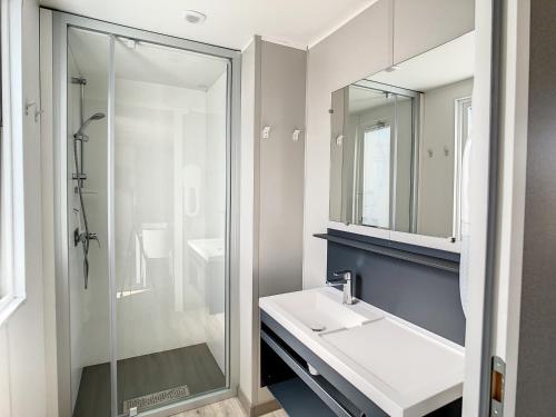 une salle de bain avec un lavabo et une douche dans l'établissement Mobil-home 6 pers, 3 chambres, piscine chauffée, plage à 200m, terrasse couverte - FR-1-361A-12, à Jullouville