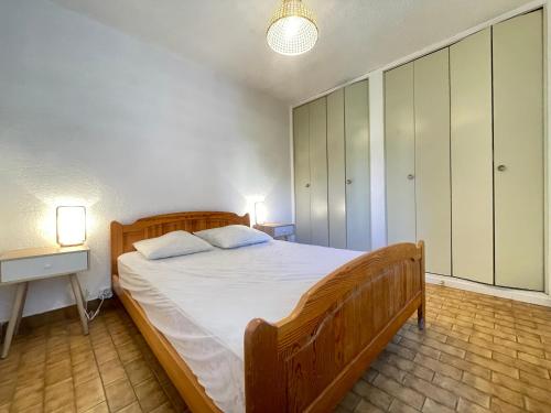 une chambre avec un grand lit et une table de chevet dans l'établissement Appartement 2 pièces face à la mer avec terrasse, parking privé et wifi à Sète - FR-1-338-526, à Sète