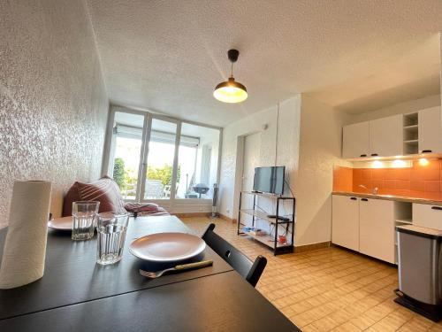 Il comprend une cuisine et une salle à manger avec une table. dans l'établissement Appartement 2 pièces face à la mer avec terrasse, parking privé et wifi à Sète - FR-1-338-526, à Sète