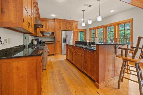 a kitchen with wooden cabinets and black counter tops at Grand Fireplace Pool Table Wifi Sleeps 18 in Lincoln