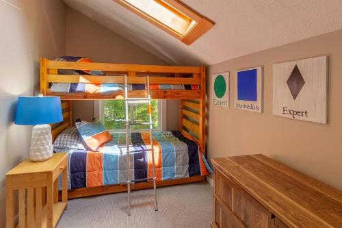 a bedroom with two bunk beds and a table at Loon Mtn Pool Hot Tub Firepit Sleeps 17 in Lincoln